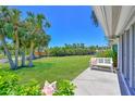 View of backyard with palms and bench overlooking canal and foliage at 4726 Potomac Cir, Bradenton, FL 34210