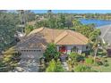 Aerial view of home with a clay tile roof and mature landscaping near a serene lake at 4978 Cedar Oak Way, Sarasota, FL 34233