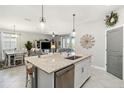 Open kitchen area with an island, stainless steel dishwasher, and seamless flow to living and dining at 5165 Coral Reef Way, Bradenton, FL 34211