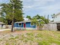 Charming blue home featuring a bright red door, stone accents, and well-manicured landscaping at 5307 47Th Street E Ct, Bradenton, FL 34203