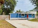 Charming blue home featuring a bright red door, stone accents, and a newly installed driveway at 5307 47Th Street E Ct, Bradenton, FL 34203