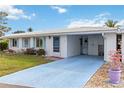 Inviting single-story home showcasing a well-kept lawn, a quaint front door, and a covered carport at 577 Circlewood Dr # X7, Venice, FL 34293