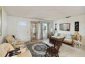 Bright and airy living room with comfortable seating, tiled floors, a display cabinet, and a large rug at 577 Circlewood Dr # X7, Venice, FL 34293