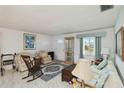 Cozy living room featuring vintage furniture, marble floors, and ample natural light from the window at 577 Circlewood Dr # X7, Venice, FL 34293