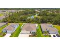 Aerial view of well-manicured home with a large driveway, colorful landscaping, and a community pond nearby at 5904 114Th E Dr, Parrish, FL 34219