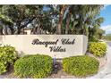 Racquet Club Villas sign surrounded by lush landscaping at community entrance at 6203 Courtside Dr # 21, Bradenton, FL 34210