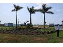 Community entrance featuring lush landscaping, a decorative monument, and a sales center at 650 Maldives Trl, Sarasota, FL 34234