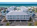 Aerial view showcasing a beach-front condo complex with lush landscaping and ocean views at 7000 Gulf Dr # 205, Holmes Beach, FL 34217