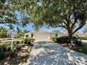 Well-maintained single-story home with a two-car garage and mature trees at 7330 Kensington Ct, University Park, FL 34201