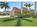 Charming two-story home featuring lush landscaping, a vibrant green lawn, and a two-car garage at 7626 Double Pine Dr, Sarasota, FL 34240