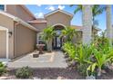 Inviting front entrance with a fountain feature, lush landscaping, and a stylish, glass-paneled front door at 7626 Double Pine Dr, Sarasota, FL 34240