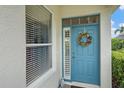 Charming blue front door with decorative wreath and sidelight window at 7821 Troon Ct, Lakewood Ranch, FL 34202