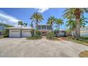 Charming two-story home with lush landscaping, a three-car garage, and a welcoming brick path at 878 Freeling Dr, Sarasota, FL 34242