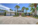 Charming two-story home with lush landscaping, a three-car garage, and a welcoming brick path at 878 Freeling Dr, Sarasota, FL 34242