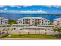 Apartment building exterior with waterfront view and parking, enhanced by a vibrant blue sky with picturesque clouds at 910 Tidewater Shores Loop # 103, Bradenton, FL 34208