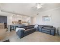 Spacious living room with kitchen in background featuring tile floors, couch, and bright lighting at 910 Tidewater Shores Loop # 103, Bradenton, FL 34208