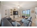 Comfortable living room with large sectional couch, entertainment center, and access to an outdoor patio at 910 Tidewater Shores Loop # 103, Bradenton, FL 34208