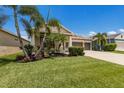 Gorgeous home featuring lovely manicured landscaping, a bright green lawn, and beautiful palm trees at 11513 11Th E Ave, Bradenton, FL 34212