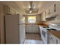 Bright kitchen with white appliances, ceiling fan, and tile flooring for easy maintenance at 1214 56Th W St # 1214, Bradenton, FL 34209