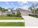 Charming single-Gathering home with a two-car garage and a well-manicured lawn and landscaping with several palm trees at 12339 Glenridge Ln, Parrish, FL 34219