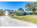 Charming single-story home featuring a gravel driveway and a light gray exterior at 1234 29Th St N, St Petersburg, FL 33713