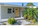 Inviting front entrance with yellow door, charming plants, and modern mailbox at 1234 29Th St N, St Petersburg, FL 33713