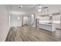 Spacious living room showcasing hardwood floors, recessed lighting, elegant chandeliers, and an open kitchen concept at 12822 Del Corso Loop, Bradenton, FL 34211