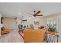 Comfortable living room with a fireplace, ceiling fan, hardwood floors, and elegant furnishings at 1432 Colony Pl, Venice, FL 34292