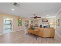 Bright living room features hardwood floors, a ceiling fan, a fireplace, and neutral walls at 1432 Colony Pl, Venice, FL 34292