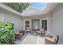 A cozy, covered front porch area with four chairs provides a relaxing outdoor space at 1432 Colony Pl, Venice, FL 34292