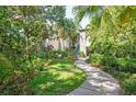 Condo building surrounded by lush landscaping, inviting walkway and mature trees at 1629 Pelican Cove Rd # 138A, Sarasota, FL 34231