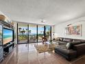 Comfortable living room with tile floors, water view, and sliding glass doors to the balcony at 2120 Harbourside Dr # 617, Longboat Key, FL 34228