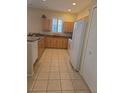 The kitchen features tile flooring, wooden cabinets, granite countertops and white appliances at 24028 Park Place S Dr # 32, Punta Gorda, FL 33980