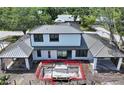 Aerial view of a two-story home featuring a gray metal roof, and in-ground pool under construction in the backyard at 2485 S Milmar Dr, Sarasota, FL 34237