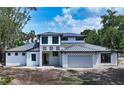 Newly constructed two-story home featuring a stone facade, black trim windows, and a gray garage door at 2485 S Milmar Dr, Sarasota, FL 34237