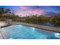 Inviting waterfront pool with lounge chairs and a tranquil view of the surrounding nature at 306 68Th St, Holmes Beach, FL 34217