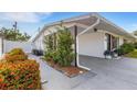 View of the side exterior showcasing a carport, lush landscaping, and the home's architectural features, ensuring a welcoming experience at 3219 Florida Blvd, Bradenton, FL 34207
