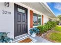 Close-up of the front door with a decorative welcome mat and stylish planters, enhancing the home's entrance appeal at 3219 Florida Blvd, Bradenton, FL 34207