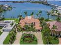 Aerial view of the Mediterranean-style home with lush landscaping, and waterfront access at 3576 San Remo Ter, Sarasota, FL 34239