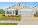 Charming single-story home with a gray exterior, well-manicured lawn, and a two-car garage at 3834 Silver Strand Trl, Palmetto, FL 34221