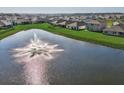 A tranquil pond featuring a fountain is surrounded by lush green grass at 3834 Silver Strand Trl, Palmetto, FL 34221