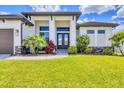 Close-up of front entrance featuring an elegant door, decorative plants, and a well-maintained lawn at 4312 Vasco St, Punta Gorda, FL 33950