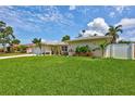 Lovely single-story home featuring a lush green lawn, landscaping, and a white fence for privacy at 5126 15Th W Ave, Bradenton, FL 34209