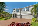 Charming home boasting a three-car garage, brick driveway, manicured landscaping, and a well-maintained lawn at 5805 49Th E Ct, Ellenton, FL 34222