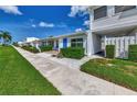 Inviting villa showcasing a bright blue front door, lush landscaping, and a convenient carport at 5858 Midnight Pass Rd # 27, Sarasota, FL 34242