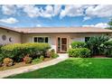 Inviting front entrance featuring a well-manicured lawn, mature landscaping, and a charming pathway at 6011 91St E St, Bradenton, FL 34202