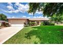 Well-maintained single-story home with lush green lawn, an attached two-car garage and charming landscaping at 6011 91St E St, Bradenton, FL 34202