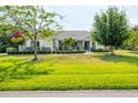 Charming single-story home showcasing a well-manicured lawn, complemented by mature trees and landscaping at 6102 9Th Avenue Cir Ne, Bradenton, FL 34212
