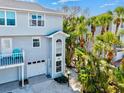 The light blue home exterior boasts a balcony, tropical landscaping, and garage at 6250 Holmes Blvd # 63, Holmes Beach, FL 34217