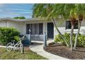Inviting front entrance with seating and a bicycle, enhanced by lush landscaping and natural light at 6442 Colonial Dr, Sarasota, FL 34231